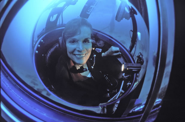 photo of a woman smiling in an underwater habitat or hard-suit