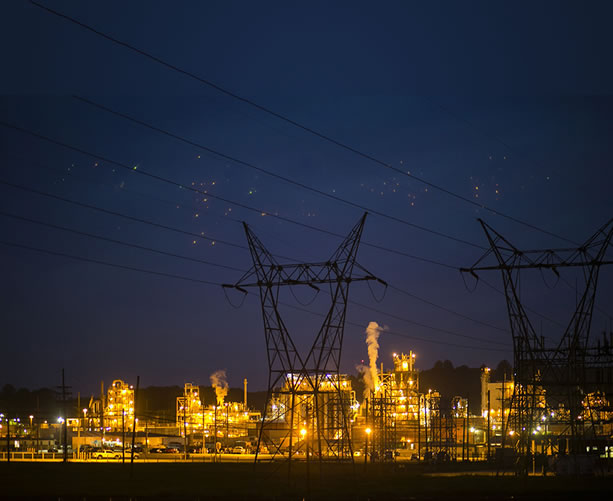 photo of a well-lit chemical factory at night