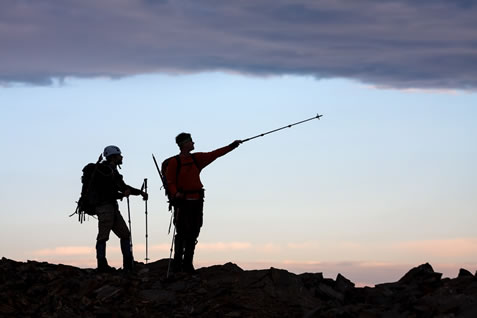 photo of backlit mountaineers on a peak