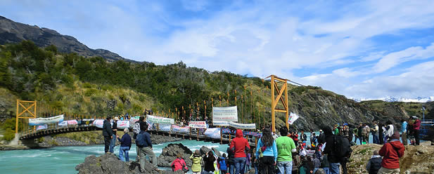 photo of demonstrators at a bridge on a river in the mountains