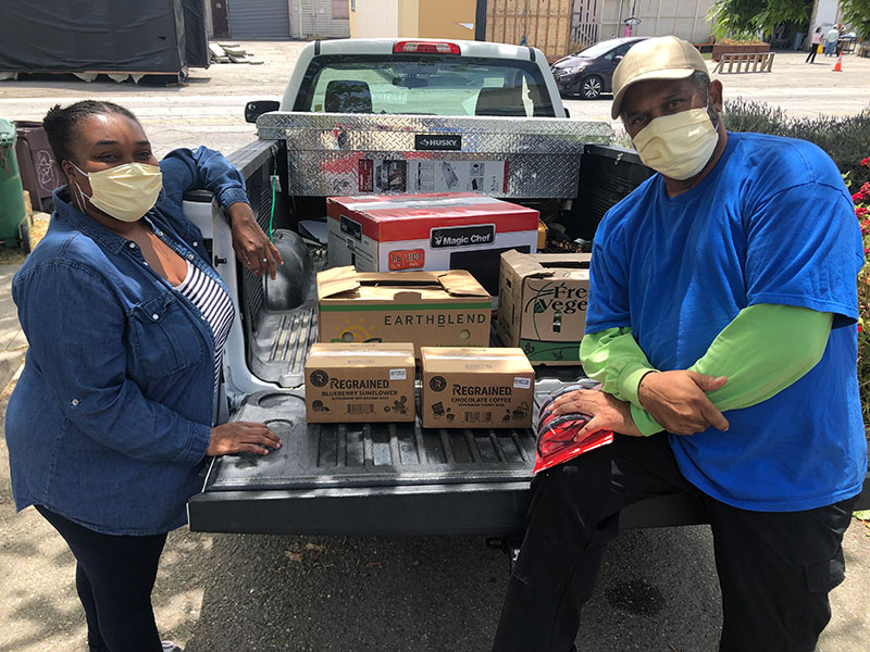 photo of masked people with grocieries in a truck