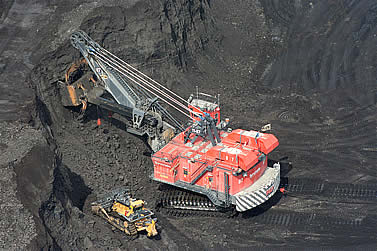 photo of a giant earthmoving machine in a black pit