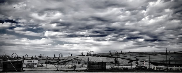 photo of a capped landfill under a threatening sky