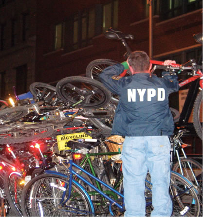 photo of a police officer piling bikes together