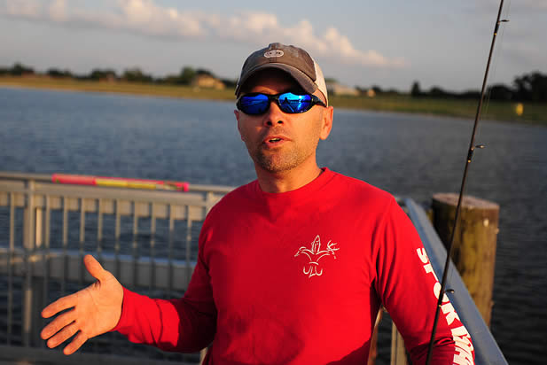 photo of a man speaking on a dock near fishing gear
