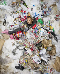 small photo of a man in a pile of snow and trash