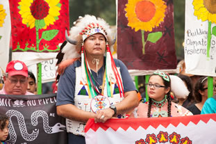 photo of demonstrators, some in American Native tribal attire
