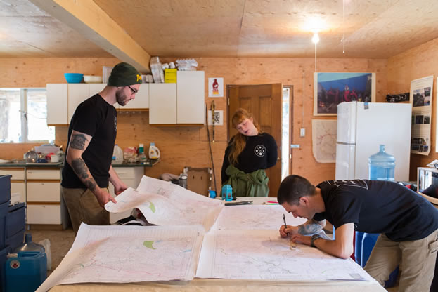 photo of people in a room making notes on a table-sized map