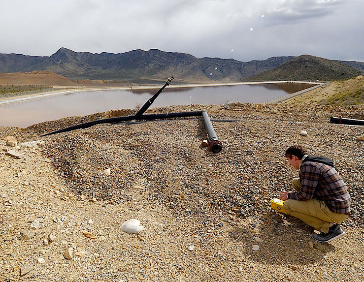 photo of a man near a mine and watercourse