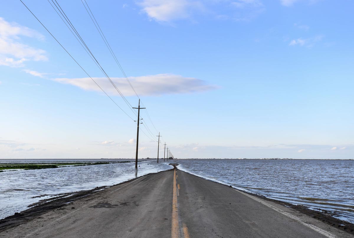 a road in farmland, awash with floodwaters